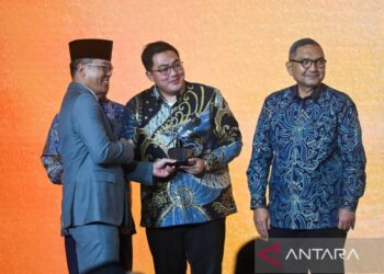 Menteri Luar Negeri Sugiono [kiri] menyerahkan piala kepada Direktur Pemberitaan ANTARA Virgandhi Prayudantoro [tengah] dalam acara PPTM 2026